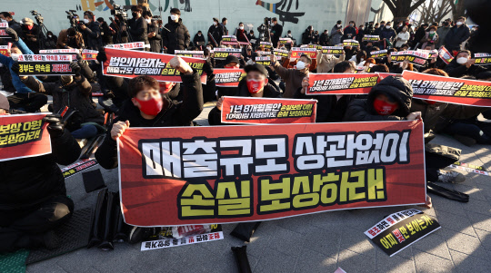 22일 오후 서울 광화문시민열린마당에서 열린 '코로나19 대응 전국자영업자비상대책위원회(자영업비대위) 정부 방역 대책 반대 총궐기 대회'에서 참석자들이 구호를 외치고 있다. <연합뉴스>